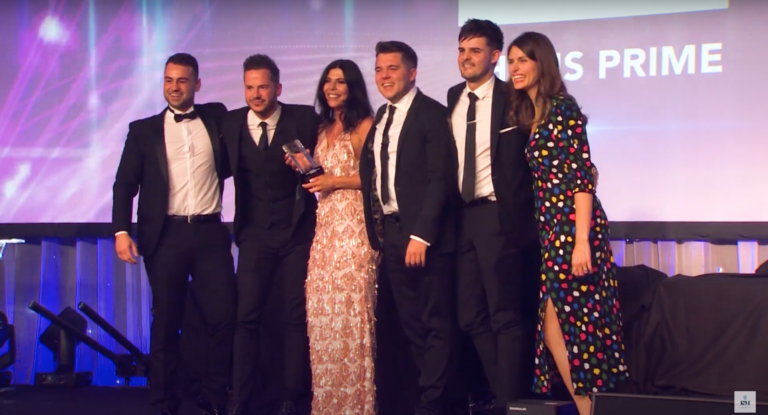 Six people posing for a photo after winning an award