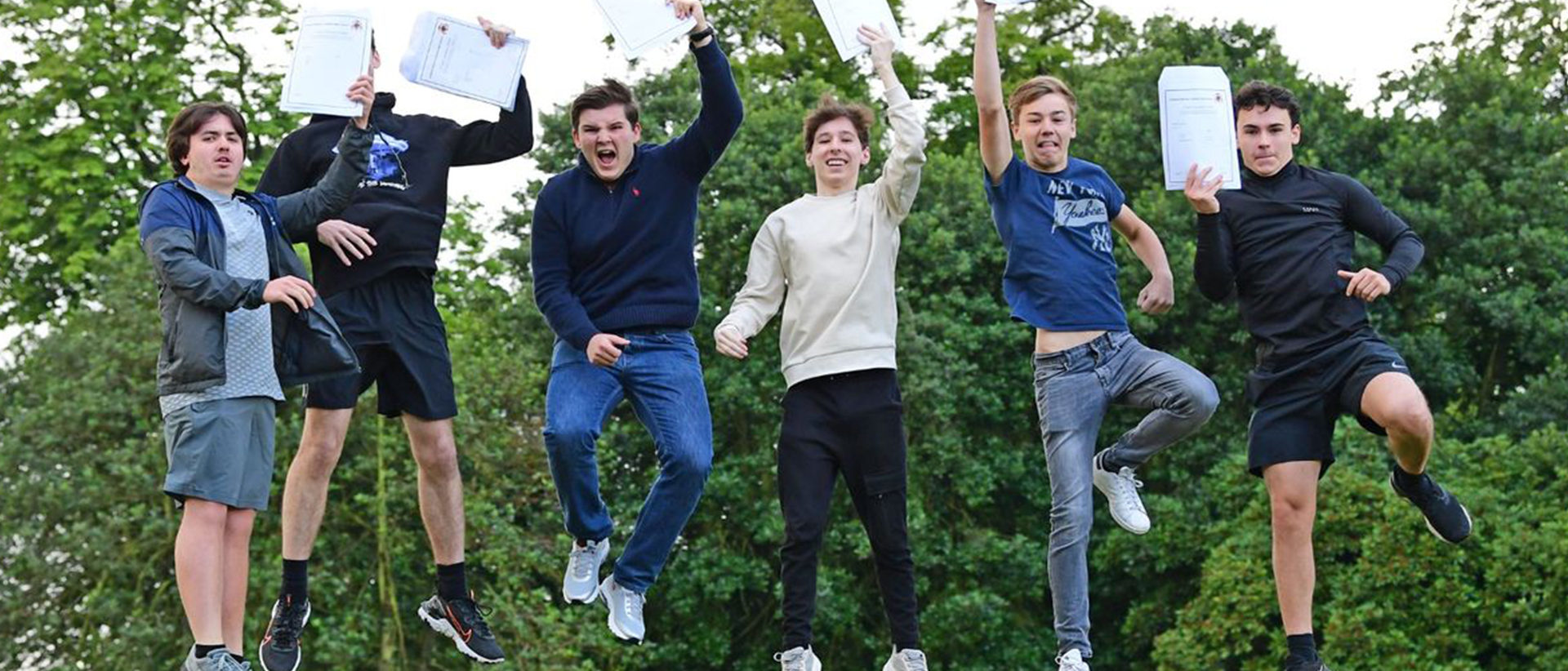 six males jumping and celebrating their exam results